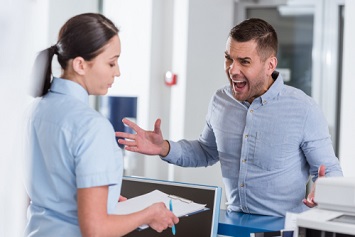 Aggressive man yelling at nurse in clinic