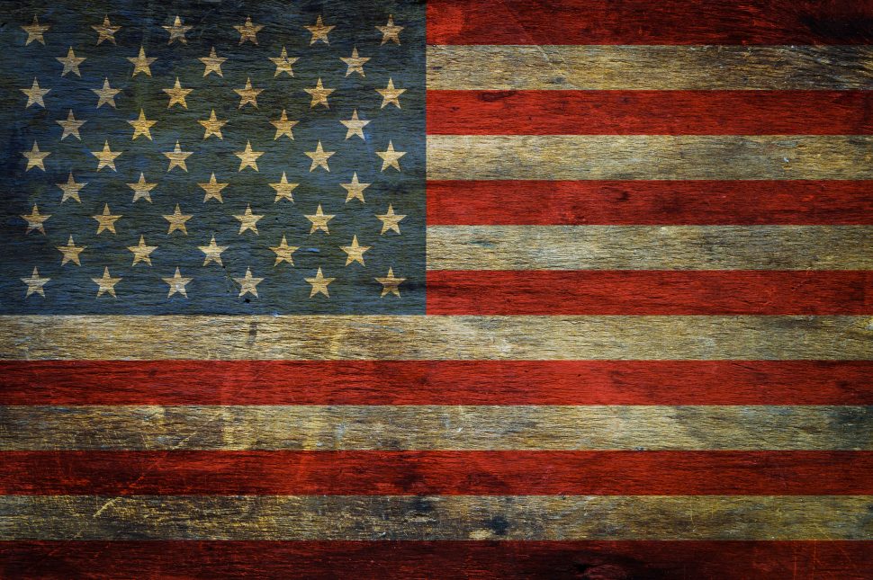 American flag on grunge wooden background - HR Daily Advisor