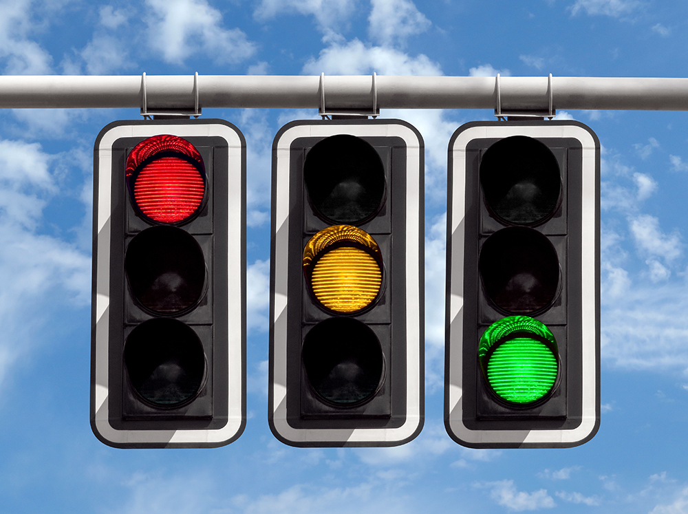 Traffic lights red yellow green against sky HR Daily Advisor